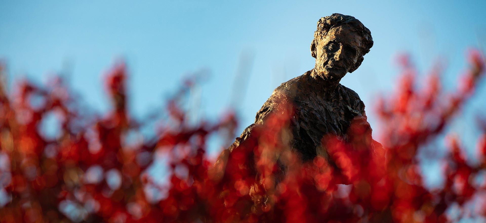 Louis Brandeis statue with red flowers in the foreground