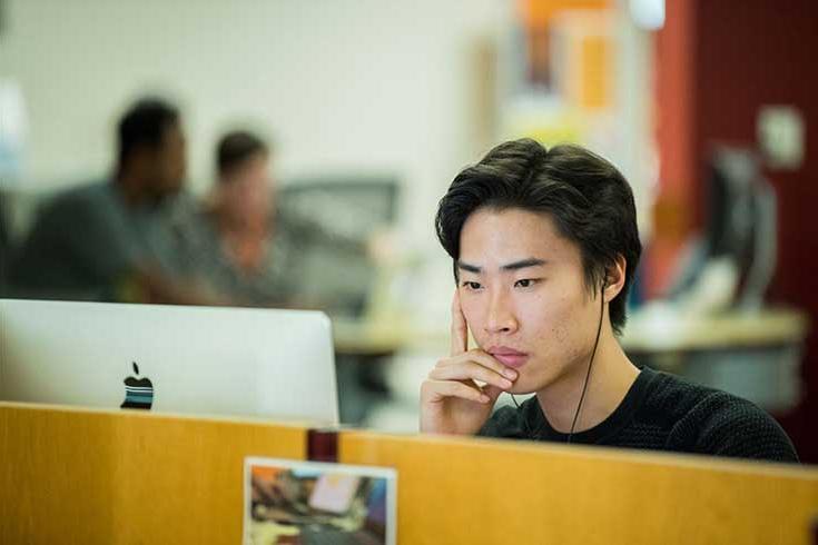 一个学生坐着看电脑